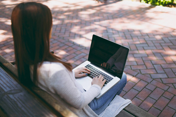 Крупним планом обрізаний успішного жіночих рук на клавіатурі. Жінка сидить на лавці, що працюють на сучасний ноутбук ПК з порожній порожній екран на вулиці, на відкритому повітрі. Мобільний офіс незалежний бізнес-концепція - Фото, зображення