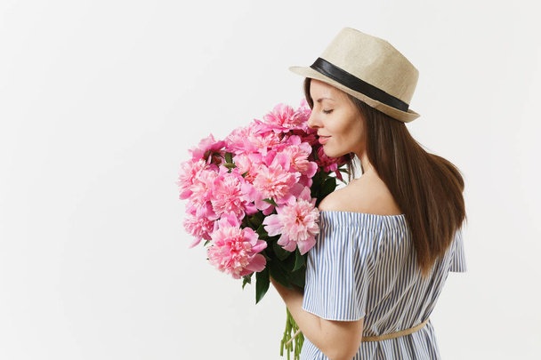 Young tender woman in blue dress, hat holding bouquet of beautiful pink peonies flowers isolated on white background. St. Valentine's Day, International Women's Day holiday concept. Advertising area - Fotografie, Obrázek
