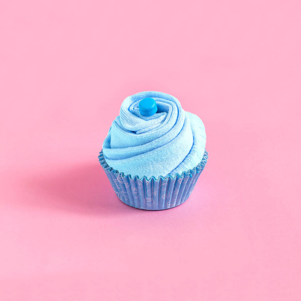 Socks in paper form for baking, imitation cupcakes. Blue composition on pink background. Minimal style. Creative idea, imagination and fantasy. Festive gift concept - Photo, Image