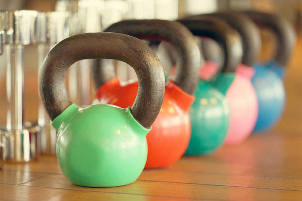 Colorful kettlebells in a row in a gym. Toning - Photo, Image