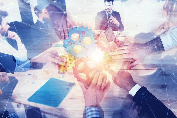 Business team connect pieces of gears. Teamwork, partnership and integration concept with network effect. double exposure - Photo, Image