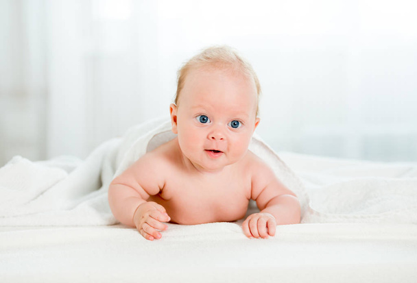 Newborn baby with beautiful blue eyes lying on belly - Fotoğraf, Görsel