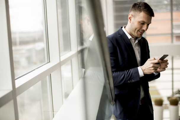 Handsome businessman using smartphone in the office - Zdjęcie, obraz