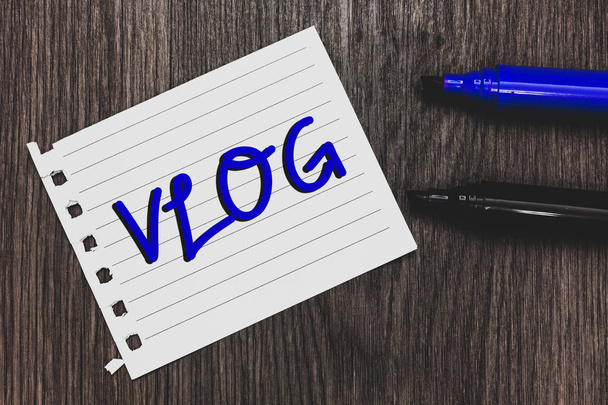Conceptual hand writing showing Vlog. Business photo text Entertaining multimedia self broadcasting news reporting stories Marker pens white paper black shadow wood ideas important tips - Photo, Image