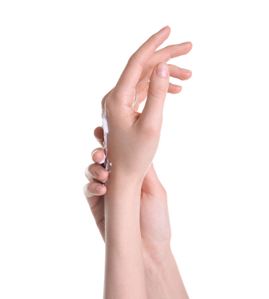 Young woman applying hand cream against on white background - Foto, Bild