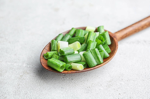 Spoon with chopped green onion on table - Foto, Imagem