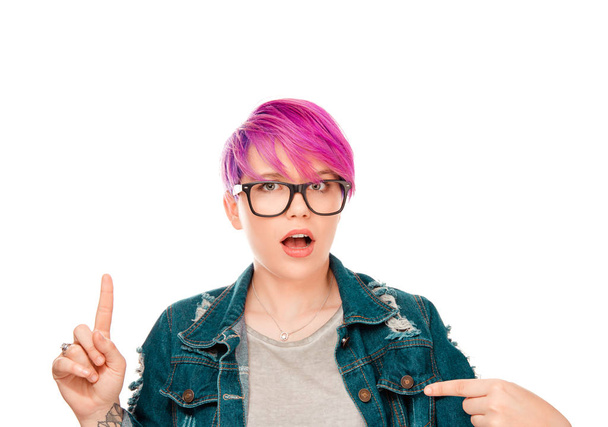 Picture of shocked woman pointing one index finger up to copy space and other at blank gray t-shirt in shock surprised isolated on white background. Studio shot horizontal image Girl with magenta hair - Foto, Imagem