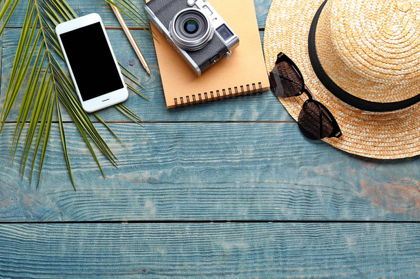Flat lay composition with stylish hat, camera and smartphone on wooden background - Photo, Image
