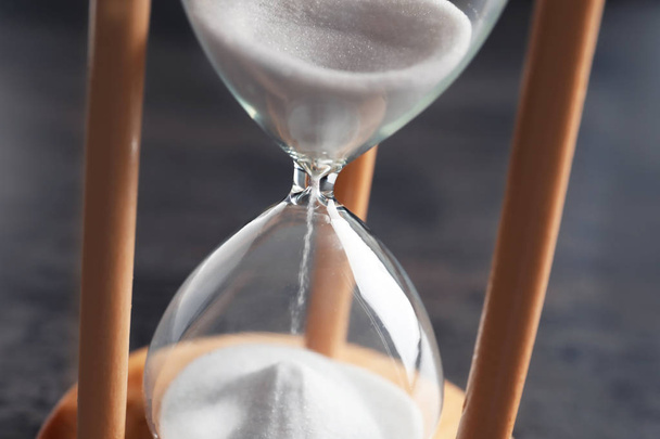Hourglass with flowing sand on table, closeup. Time management - Photo, Image
