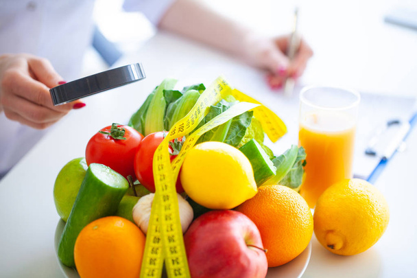Ernährung. Fitness und gesunde Ernährung. ausgewogene Ernährung mit Gemüse. frisches grünes Gemüse, Maßband auf weißem Hintergrund. Nahaufnahme - Foto, Bild