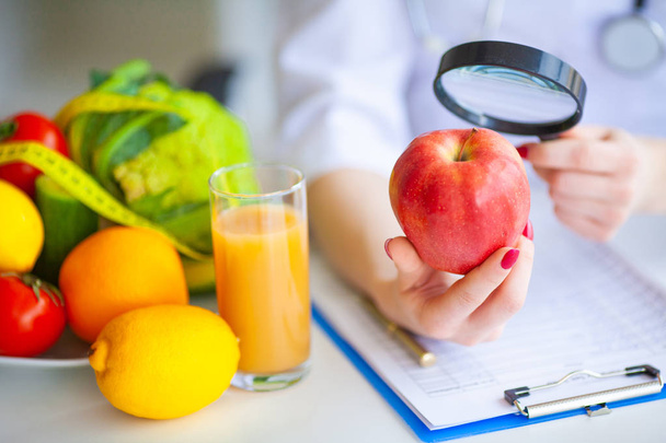Dieta. La doctora Nutricionista tiene manzana roja en su oficina. Concepto de comida natural y estilo de vida saludable. Fitness y alimentación saludable concepto de dieta. Dieta equilibrada con verduras
. - Foto, Imagen