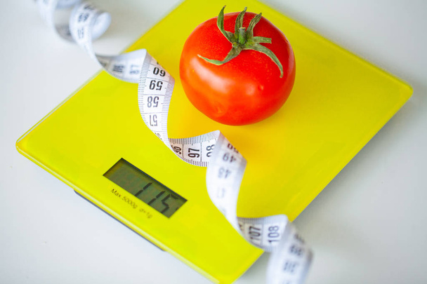 Concepto de dieta o control de peso. Frutas y verduras con cinta métrica en la escala de peso. Concepto de Fitness y Alimentación Saludable
. - Foto, Imagen
