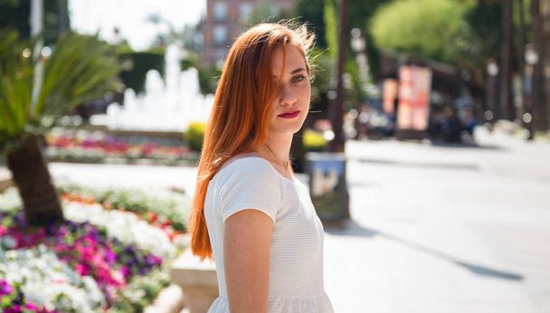 Young redhead pretty girl in a park - Фото, зображення