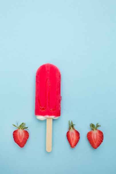 Strawberry popsicle with fresh strawberry on a blue background - Фото, изображение