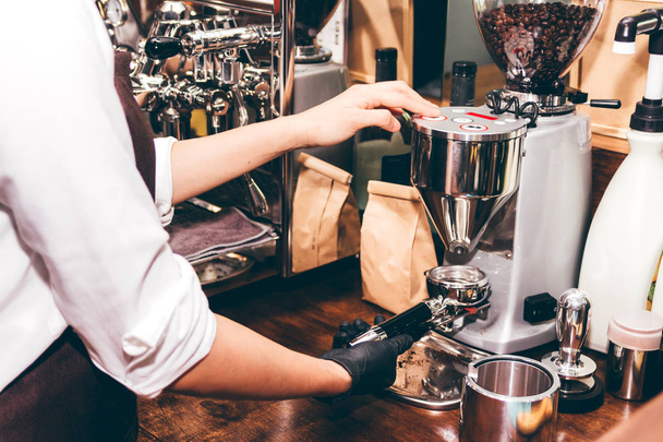 Mujer Barista utilizando máquina de café para hacer café en la cafetería
 - Foto, imagen