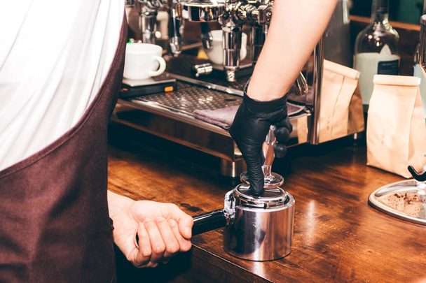 Barista using tamper to makes coffees in coffee bar - Photo, Image