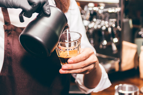 Barista holding milk for make coffee latte art in coffee shop - Foto, Bild