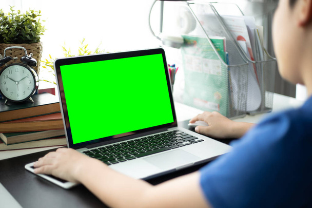 Üzerinde omuz görünümü genç çocuğun dizüstü bilgisayarda izliyor. Kullanılan teknoloji yeşil ekran.  - Fotoğraf, Görsel
