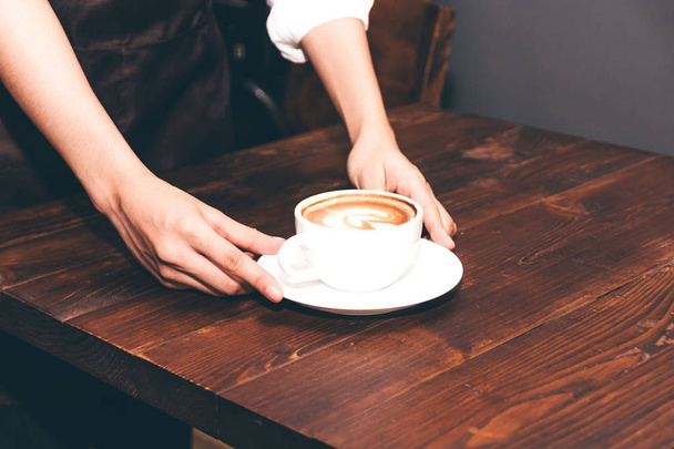 Barista holding coffee latte art in coffee shop - Фото, зображення