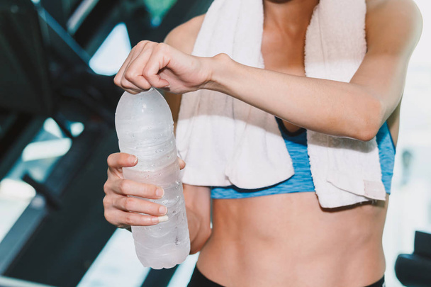 Sportif kadın holdind su şişesi havlu, gym.fitness ve yaşam tarzı kavramı ile - Fotoğraf, Görsel