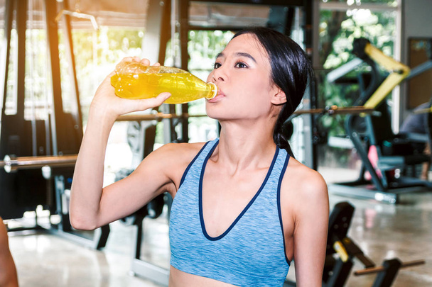Deportiva mujer sostiene botella de bebida energética en el concepto gym.fitness y estilo de vida
 - Foto, Imagen