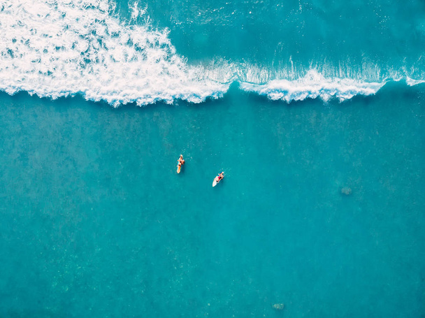 Aerial view of surfers and wave in tropical ocean. Top view - Φωτογραφία, εικόνα