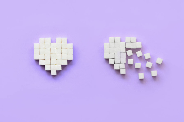 Несколько сердец из кубиков сахара лежат на модном фиолетовом фоне пастели
. - Фото, изображение