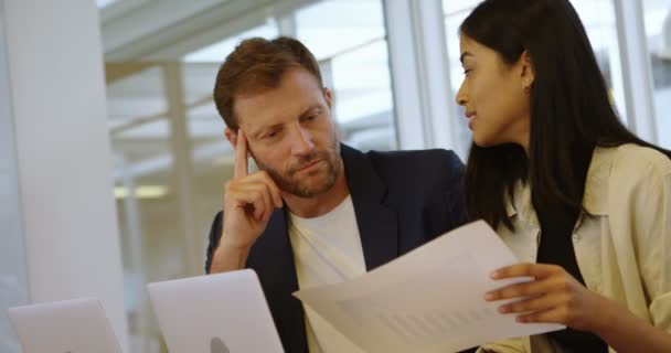 Compañeros de negocios discutiendo sobre documento en sala de conferencias en la oficina 4k
 - Metraje, vídeo
