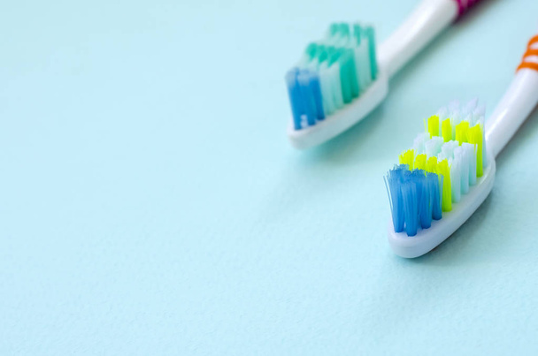 Duas escovas de dentes estão em um fundo azul pastel. Vista superior, deitado plano. Conceito mínimo
. - Foto, Imagem