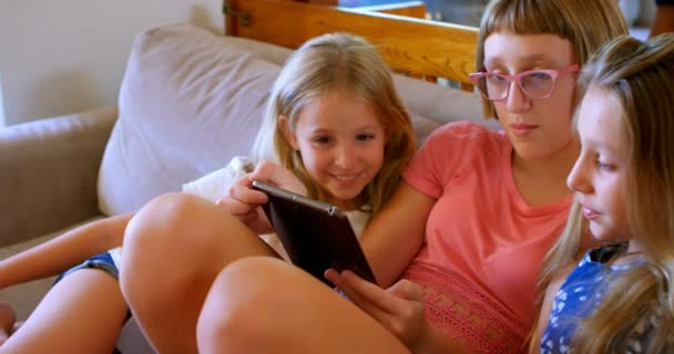 Siblings using digital tablet in living room at home 4k - Materiał filmowy, wideo