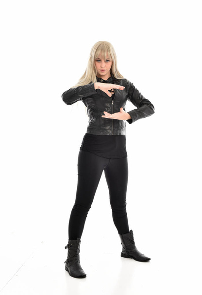 po celé délce portrét blond dívka, která nosí černé kožené oblečení, stojící pozice. izolované na bílém studio pozadí. - Fotografie, Obrázek