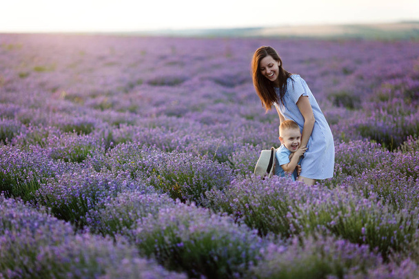 Young woman in blue dress walk on purple lavender flower meadow  - Fotoğraf, Görsel