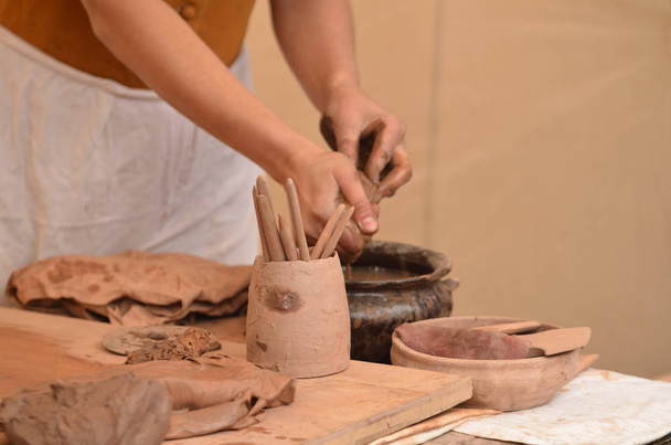 Hand of medieval craftsman female potter preparing clay - moistens and kneads the clay before work - Photo, Image