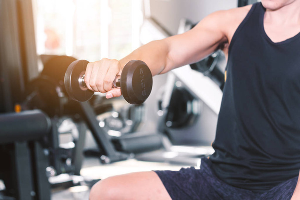 Fitness homme faisant des exercices de poids avec haltère assis à la salle de gym
 - Photo, image