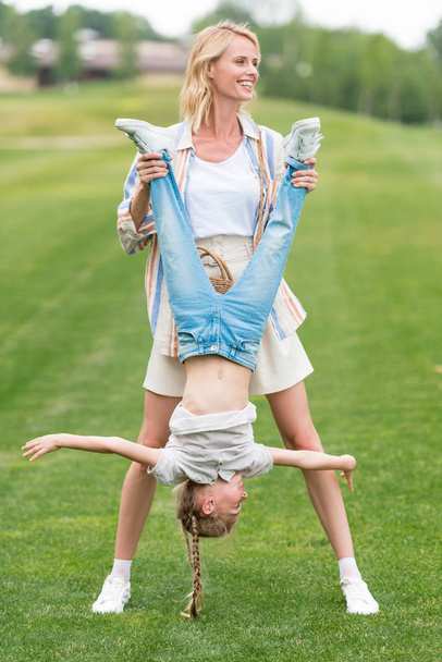 happy mother and little daughter having fun together in park  - Foto, Imagen