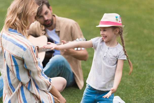 glückliche Familie mit einem Kind, das Zeit miteinander im Park verbringt - Foto, Bild