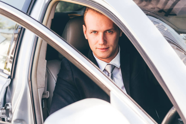 Handsome businessman in suit in a car - Foto, Bild
