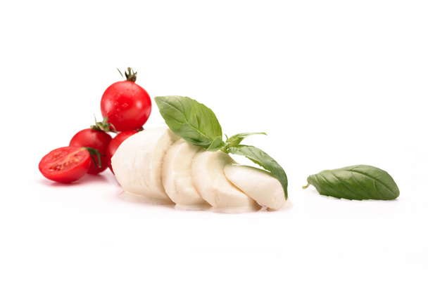 vista de cerca de tomates cherry, queso mozzarella y hojas de albahaca aisladas en blanco
 - Foto, Imagen
