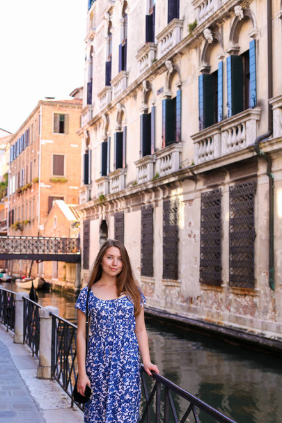 Mujer joven parada cerca de la barandilla en Venecia, Italia
. - Foto, Imagen