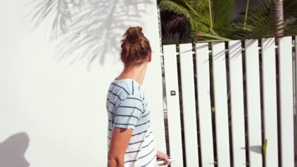 Jovem passeando ao longo da cidade resort tropical em câmera lenta
 - Filmagem, Vídeo