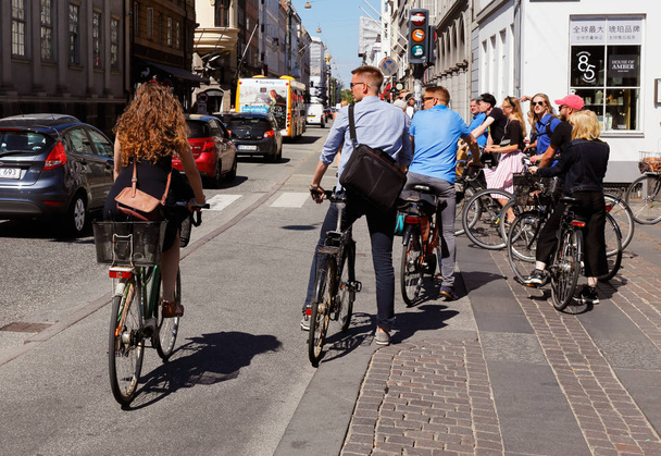 Copenhagen, Danimarka - 27 Haziran 2018: İnsanlar Bisiklet sokakları Kongens nytorv ve Bredgate için yeşil ışık bekleyen şehir bölgesinde kesişme noktalarında. - Fotoğraf, Görsel