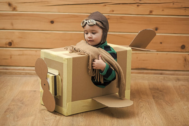 dreamy child. Brave dreamer boy playing with a cardboard airplane - Foto, afbeelding