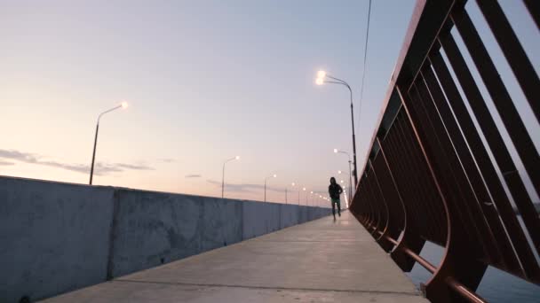 Man jogging on a bridge in city at evening - Video, Çekim