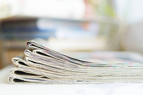 Pile of newspapers, folded and stacked journals with news. Side view, selective focus        - Photo, Image