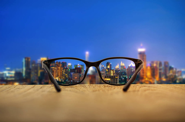 Egyértelmű városkép középpontjában a szemüveg lencsék homályos városkép háttér. - Fotó, kép
