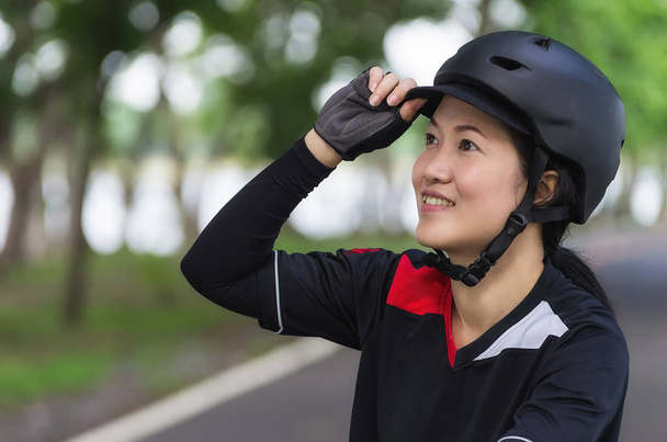Kask rowerowy - azjatyckich kobiet noszenie kasków przygotowane rowerzystów. - Zdjęcie, obraz