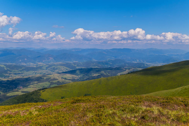Yeşil dağların mavi bulutlu gökyüzü altında ufuk ötesine - Fotoğraf, Görsel