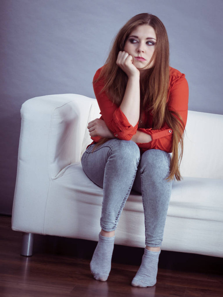 Angry, pissed off young woman. Attractive female with long brown hair sitting on sofa being mad and irritated having displeased face expression. - Foto, Bild