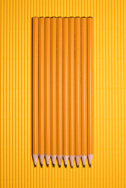 top view of arranged graphite pencils placed in row on yellow  - Fotografie, Obrázek