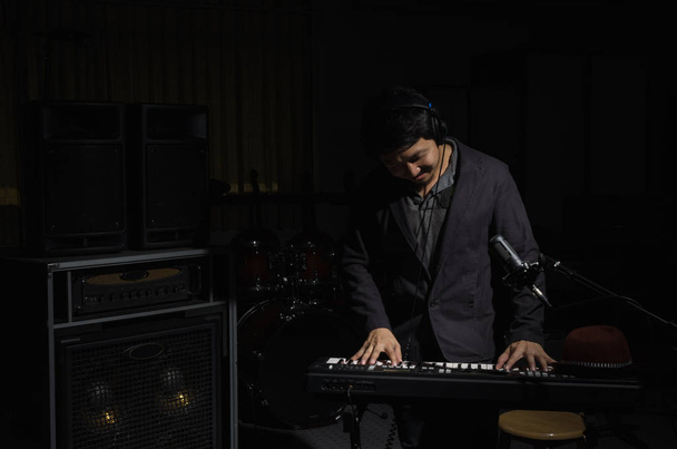 Musician playing keyboard with music instrument in dark background, Musician concept. - Φωτογραφία, εικόνα